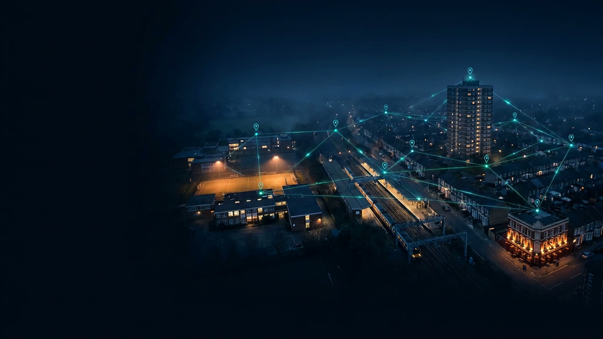 A connected UK multi-site estate at night, the sensor network pinpointing sensing data, faults, energy reduction opportunities and work orders across a campus, rail depot, tower block and pub